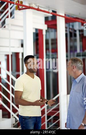 I think Im capable of taking the lead. two coworkers discussing something in a casual office environment. Stock Photo