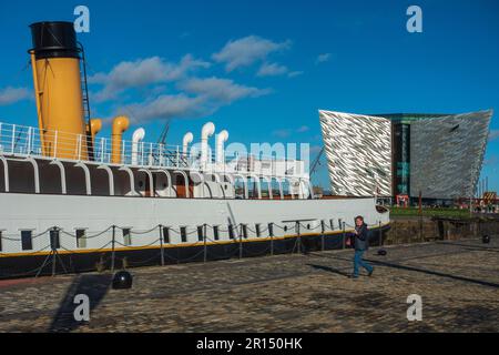 SS Nomadic in historic Hamilton Dock, with Titanic Belfast Exhibition building in background, in the Titanic Quarter, Belfast, Northern Ireland, UK Stock Photo