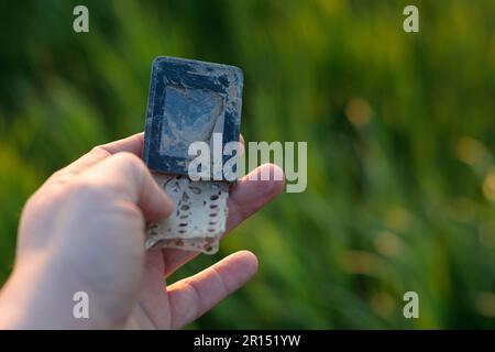 Old, broken mobile phone - recycling problem, held in hand. Stock Photo