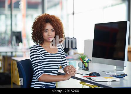 Im on the cutting edge of design. Portrait of a young office worker sitting at her workstation in an office. Stock Photo