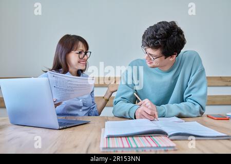 Young teenage male studying languages with teacher in classroom Stock Photo