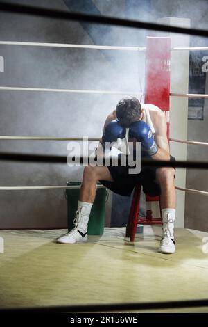 I defeated boxer sitting in his corner with his head in his hands Stock Photo