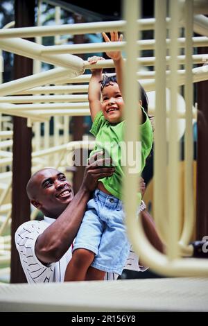 An African-American father helping his daughter add a playground Stock Photo