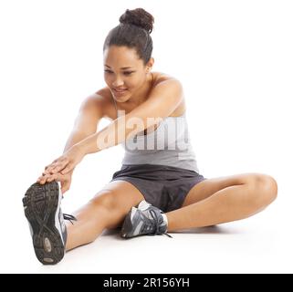 Warming up before her run. A young woman doing stretches against a white background. Stock Photo