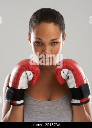 Winning the fight against obesity. A beautiful young woman wearing boxing gloves. Stock Photo