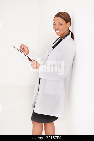The life of a professional doctor. Portrait of a smiling ethnic female doctor working on her report. Stock Photo