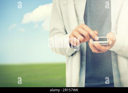 Playing with my new phone. A cropped image of a casual male typing on his cellphone. Stock Photo
