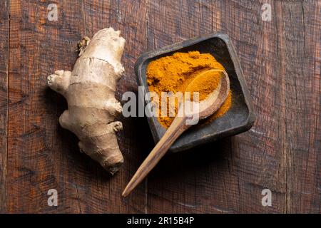Ginger root and turmeric powder on a rustic wood top view Stock Photo