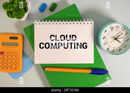 Cloud-shaped paper with text CLOUD COMPUTING on a blue background with money, houses and documents Stock Photo