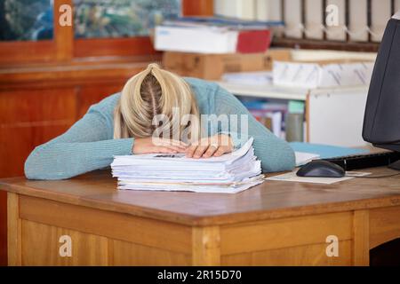 Sleeping on the job. a passed out teacher at her desk with marking papers in front of her. Stock Photo