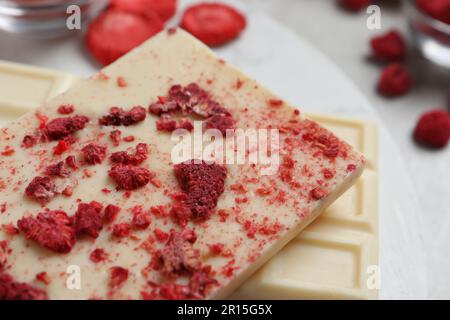 Chocolate bars with freeze dried raspberries on light marble board, closeup Stock Photo
