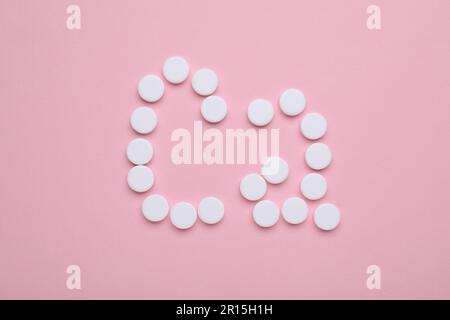 Calcium symbol made of white pills on pink background, flat lay Stock Photo