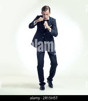 A young champion. A full length studio portrait of a young man in a boxers stance wearing a vintage suit. Stock Photo