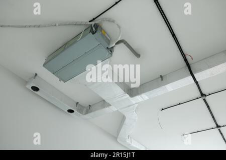 Ventilation system with pipes and wires on ceiling Stock Photo
