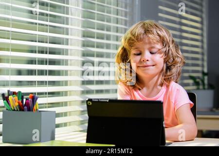 The kid boy ready to answer the online teachers question. E-learning, homeschool and online education for kids. Stock Photo
