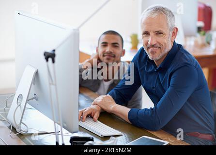He knows a thing or two. Portrait of two colleagues sitting at a computer in the office. Stock Photo