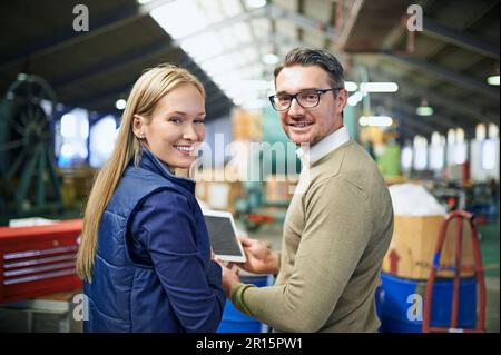 They know every inch of this warehouse. Rearview portrait of a two managers using a digital tablet while standing on the factory floor. Stock Photo