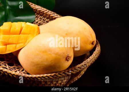Fresh Thai Mango.Barracuda mango on the wicker basket. Food and drink concept. Thai Fruits Summer Concept. Healthy fruit juice drink.horizontal. Stock Photo