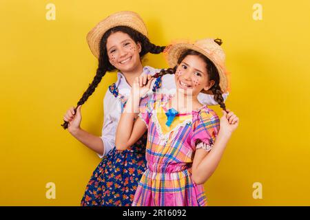 sisters and friends, wearing typical clothes of the Festa Junina. Holding hair and smiling, funny photo. Fun. Stock Photo