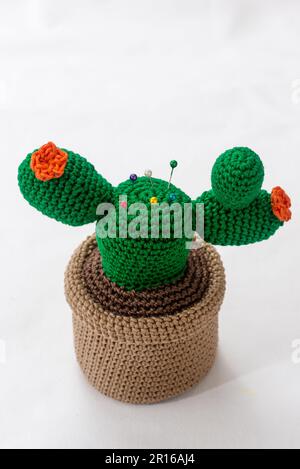 pincushion in the shape of a cactus in a pot, crocheted, on a white background Stock Photo