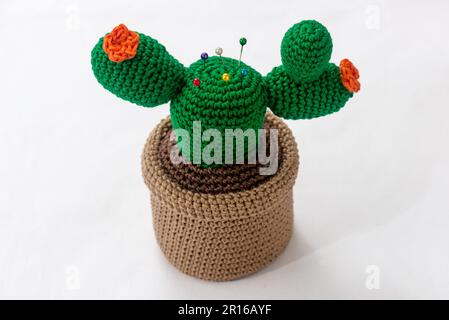 pincushion in the shape of a cactus in a pot, crocheted, on a white background Stock Photo