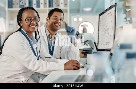 Weve been assigned a new case to solve. Portrait of two scientists working together on a computer in a lab. Stock Photo