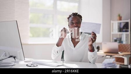 Holding Paycheck Or Payroll Check Or Insurance Cheque In Hand Stock Photo