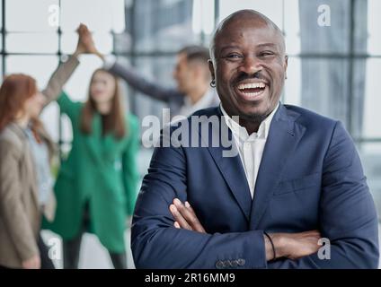 young african businessman raising his open palm against the background of colleagues Stock Photo