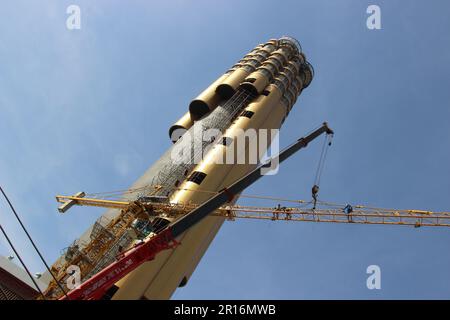 Workers dismantling a tall crane at Roi Et tower in Roi Et Thailand Stock Photo