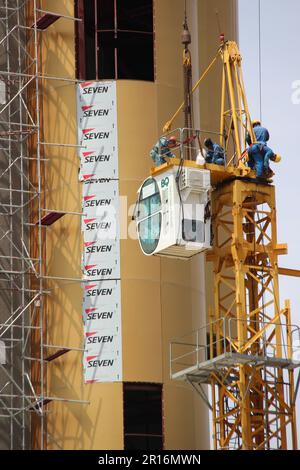 Workers dismantling a tall crane at Roi Et tower in Roi Et Thailand Stock Photo