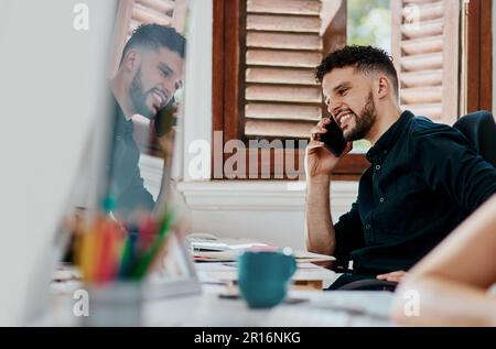 I couldnt wait to share the news...a young businessman using a smartphone in a modern office. Stock Photo