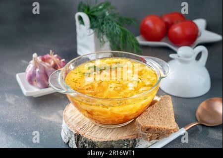 Soup is a traditional Russian soup. Cabbage, potato and meat soup in a transparent glass tureen. Traditional Russian and Ukrainian cuisine. Stock Photo