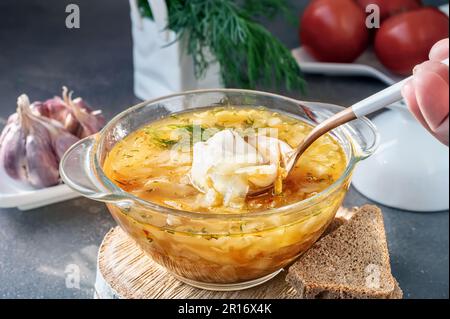 Soup is a traditional Russian soup. Cabbage, potato and meat soup in a transparent glass tureen. Traditional Russian and Ukrainian cuisine. Stock Photo