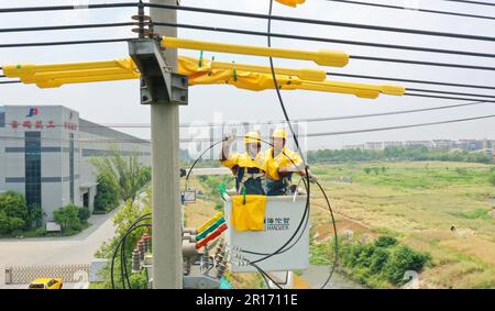 CHUZHOU, CHINA - MAY 12, 2023 - Workers replace the smart switch on the 25 pole of the 10 kV Yuhong 132 line, Chuzhou City, Anhui Province, China, May Stock Photo