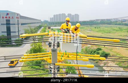 CHUZHOU, CHINA - MAY 12, 2023 - Workers replace the smart switch on the 25 pole of the 10 kV Yuhong 132 line, Chuzhou City, Anhui Province, China, May Stock Photo