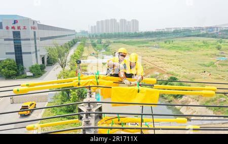 CHUZHOU, CHINA - MAY 12, 2023 - Workers replace the smart switch on the 25 pole of the 10 kV Yuhong 132 line, Chuzhou City, Anhui Province, China, May Stock Photo