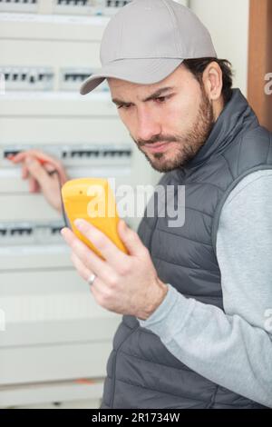 electrician works in a switchboard Stock Photo