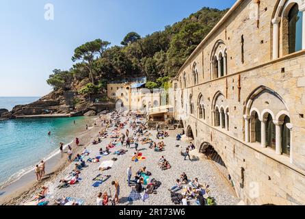 Ancient San Fruttuoso Abbey, X-XI century. Beach crowded with tourists near Portofino and Camogli, Genoa province (Genova), Liguria, Italy, Europe. Stock Photo