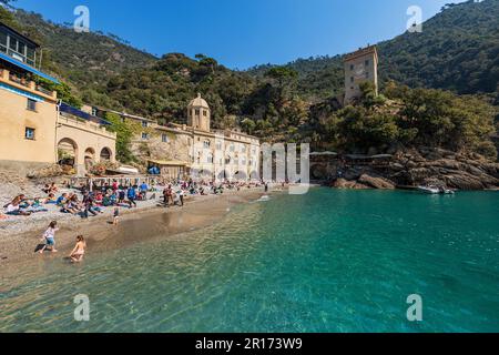 Ancient San Fruttuoso Abbey, X-XI century. Beach crowded with tourists near Portofino and Camogli, Genoa province (Genova), Liguria, Italy, Europe. Stock Photo