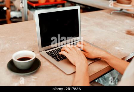 Its important to get your work out there. a artisan using a laptop in her workshop. Stock Photo