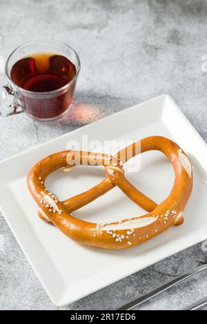 Pretzel in white porcelain plate on stone background Stock Photo