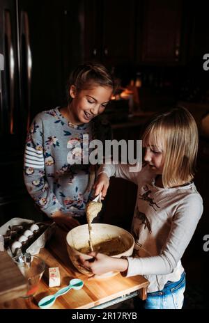 two young girls baking in kitchen Stock Photo