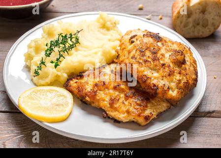 German schnitzel with fresh mashed potatoes close up. Homemade breaded pork meat chop. Wiener Schnitzel. Stock Photo