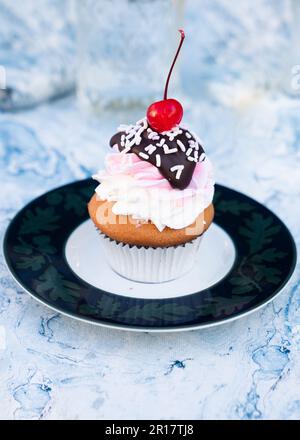 Frosted cupcake with cherry on top Stock Photo