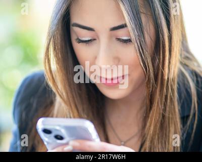 asian race female model using smartphone outdoors Stock Photo