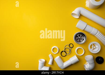 plumbing pvc plastic parts on yellow background with copy space Stock Photo