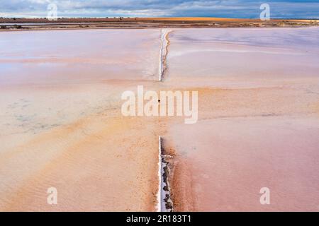 Aerial view of a break in a fence line amid a wide salt lake at Sealake in Victoria, Australia Stock Photo