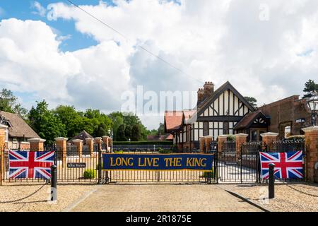 Flags & a banner celebrating the coronation of King Charles III at the old Wolferton statiion on the Sandringham Estate. Stock Photo