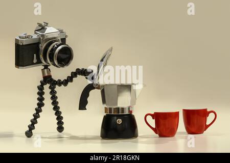 A photo of a camera brewing  coffe with moka pot and two coffee red mugs Stock Photo