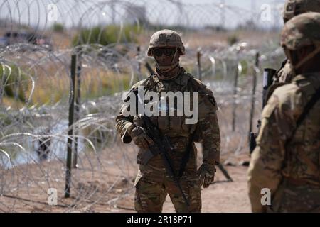 Members of the Operation Lone Star Task Force West and Texas Tactical Border Force block migrants from illegally entering Texas, May 11, 2023 near El Paso on the Rio Grande River. The units assumed blocking positions behind previously installed concertina wire in preparation for the expiration of Title 42.Members of the Operation Lone Star Task Force West and Texas Tactical Border Force block migrants from illegally entering Texas, on May 11, 2023, near El Paso on the Rio Grande River. The units assumed blocking positions behind previously installed concertina wire in preparation for the expir Stock Photo